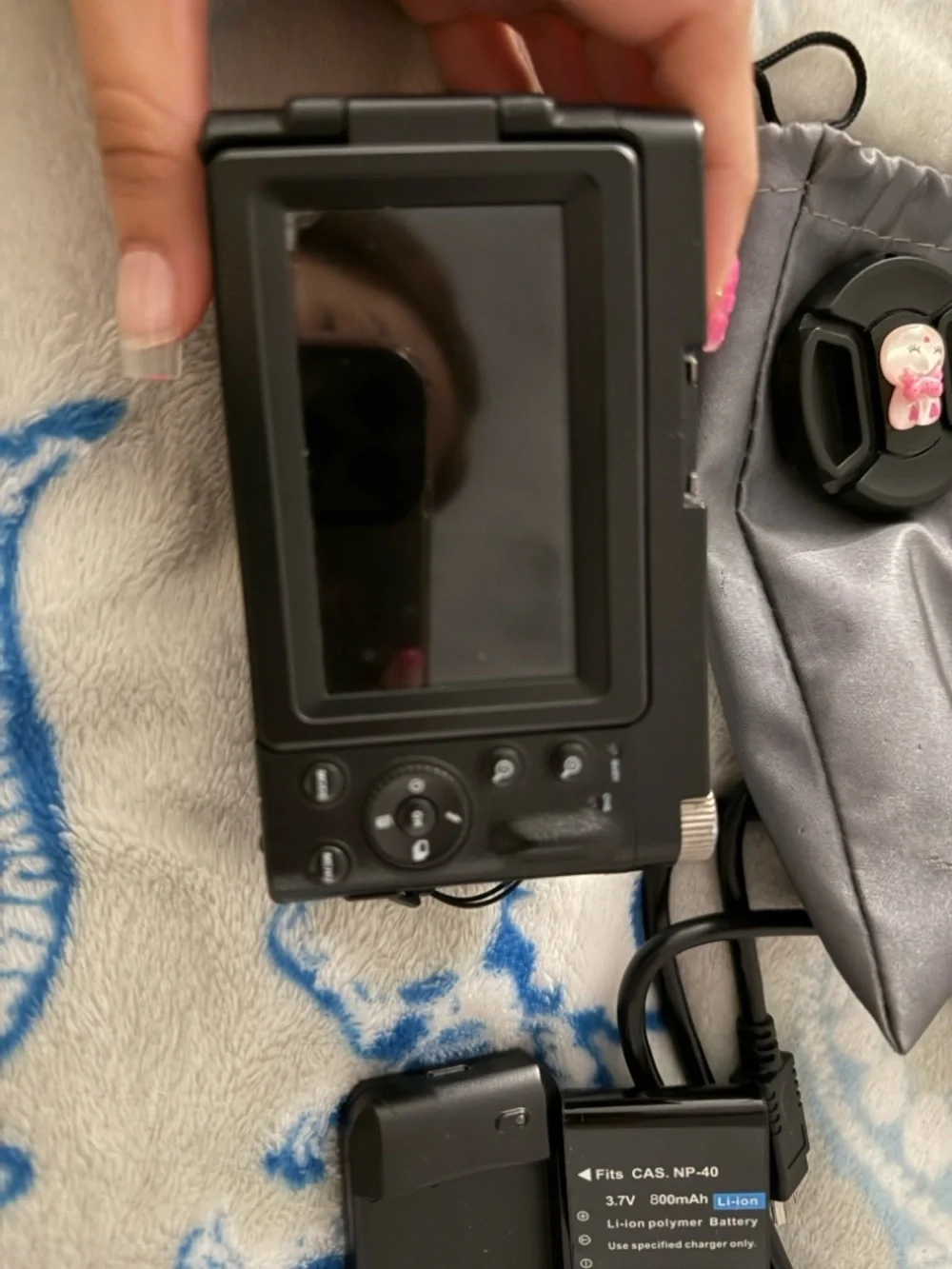 Black Compact Digital Camera with Lens Cap and Charger